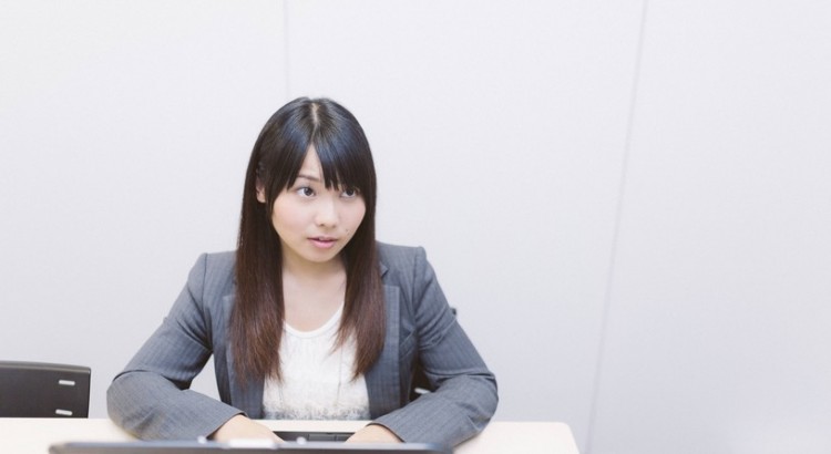 アイコンタクトでプレゼン中の部下に指示を出す先輩社員 ［モデル：Lala］