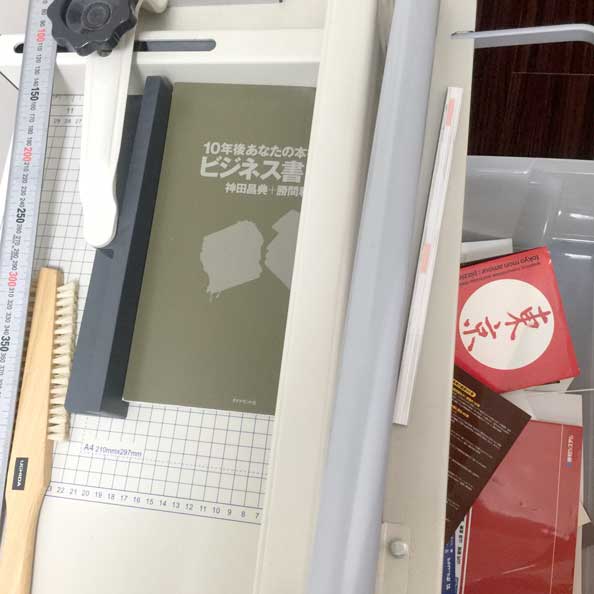 大型裁断機 ペーパーカッターで、書籍の「背」を裁断。